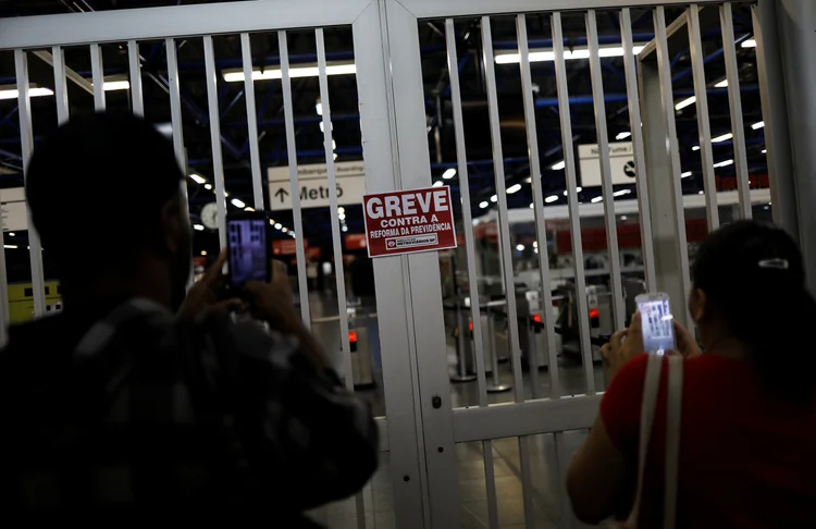 Passageiros tiram foto de aviso de greve na estação Barra Funda do metrô de São Paulo (Nacho Doce/Reuters)