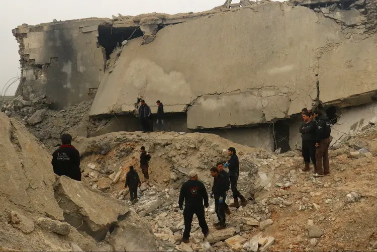 Homens observam escombros após ataque à mesquita na Síria: grupo rebelde disse que ataques a mesquitas e locais de culto são considerados crimes de guerra na maioria dos códigos legais (Ammar Abdullah/Reuters)
