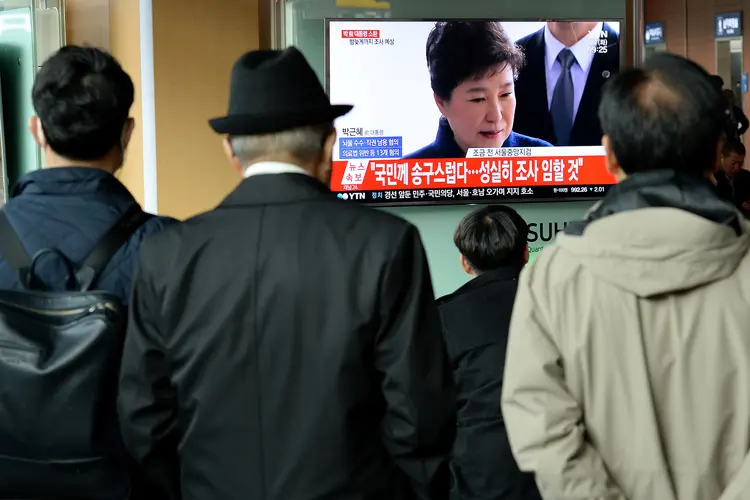 Pessoas assistem às declarações de Park Geun-hye, ex-presidente da Coreia do Sul (Foto/Reuters)