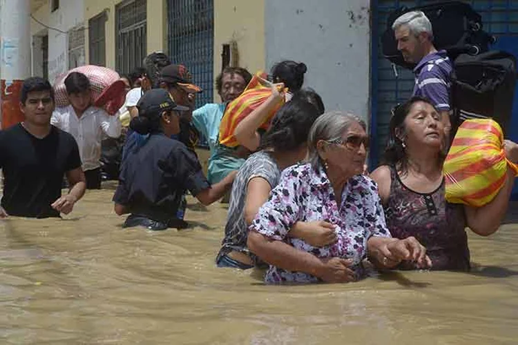 Moradores atravessam  rua inundada em Piura, no Peru, em 27 de março de 2017.  (Miguel Arreategu/Reuters)