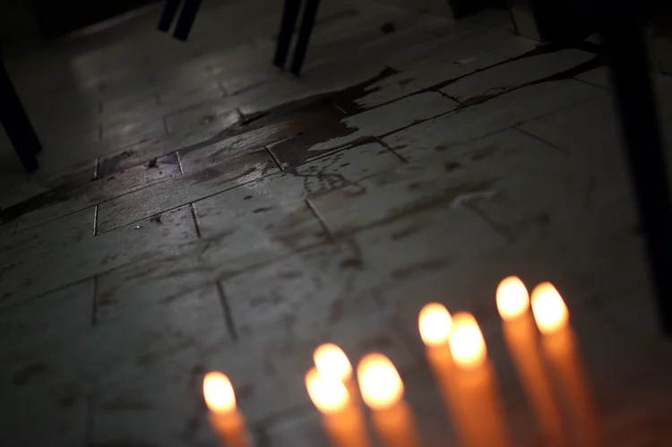 Candles are seen in front of the bloodstains of Rodrigo Quintana, who was killed last night by a rubber bullet fired by the police in the headquarters of the Liberal Party, after clashes in Asuncion, Paraguay, April 1, 2017. REUTERS/ (Marcos Brindicci/Reuters)