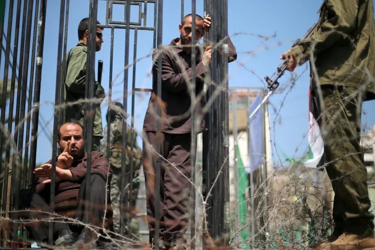 Manifestantes simulam prisão israelense durante protesto em apoio a detentos palestinos no país (Mohammed Salem/Reuters)