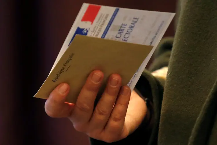 Eleições na França: homem segura cédula eleitoral para votar no primeiro turno (REUTERS/Christian Hartmann/Reuters)