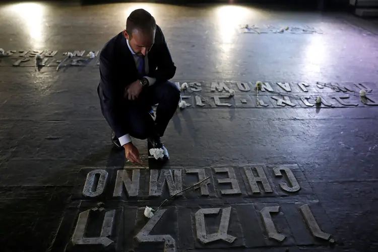 Visitante deixa flor em homenagem às vítimas do Holocausto em memorial em Jerusalém (Amir Cohen/Reuters)