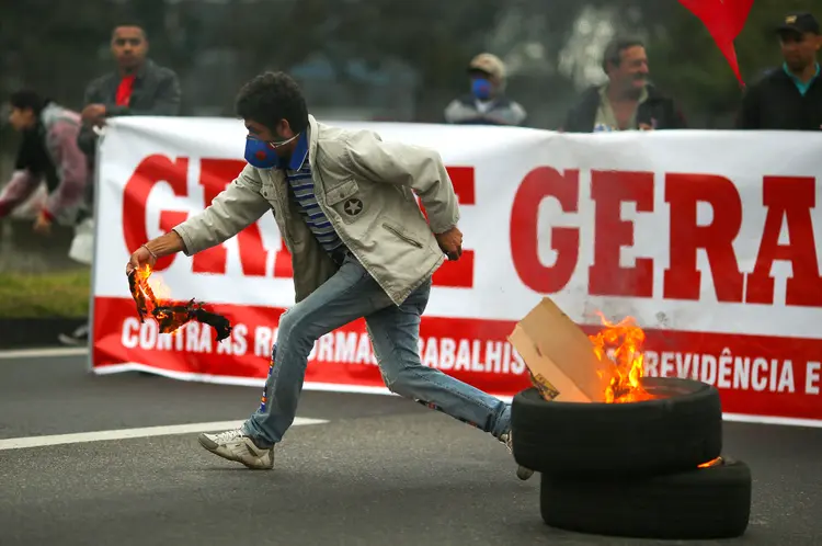Manifestante prepara barricada na rodovia Dutra, durante greve geral, contra medidas do governo Temer (Roosevelt Cassio/Reuters)