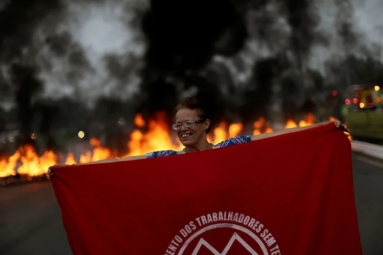 Membro do MTST segura bandeira em bloqueio durante greve geral de 28/04 em Brasília (DF) (Ueslei Marcelino/Reuters)