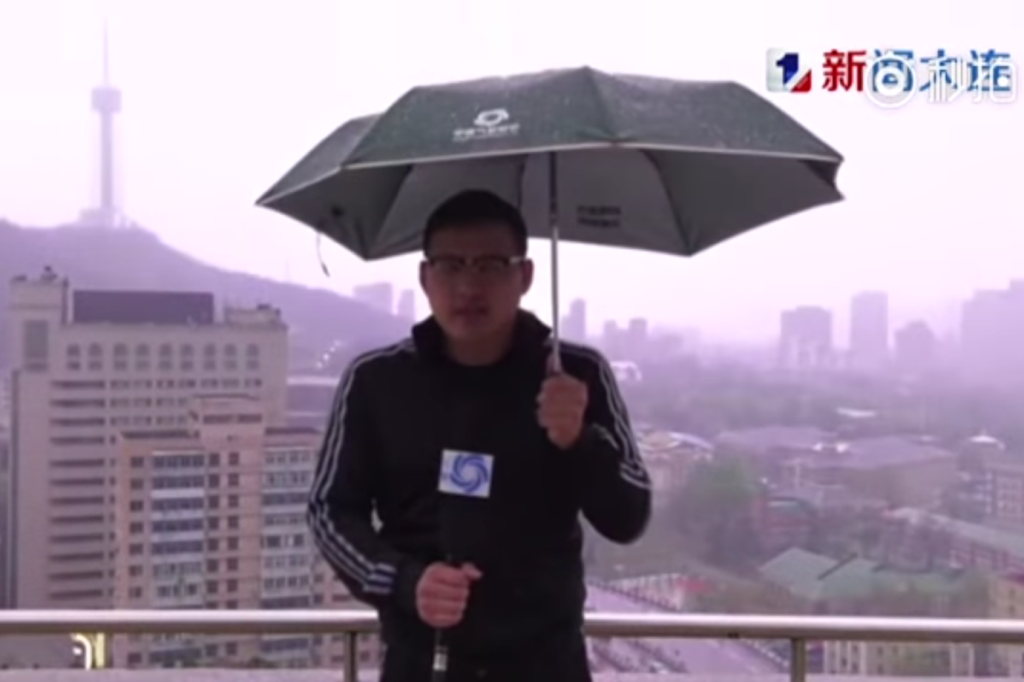 Repórter contou mais tarde à "Dalian TV" que via faíscas ao redor de sua mão e no guardas-chuvas que o câmera segurava (Reprodução/Foto)