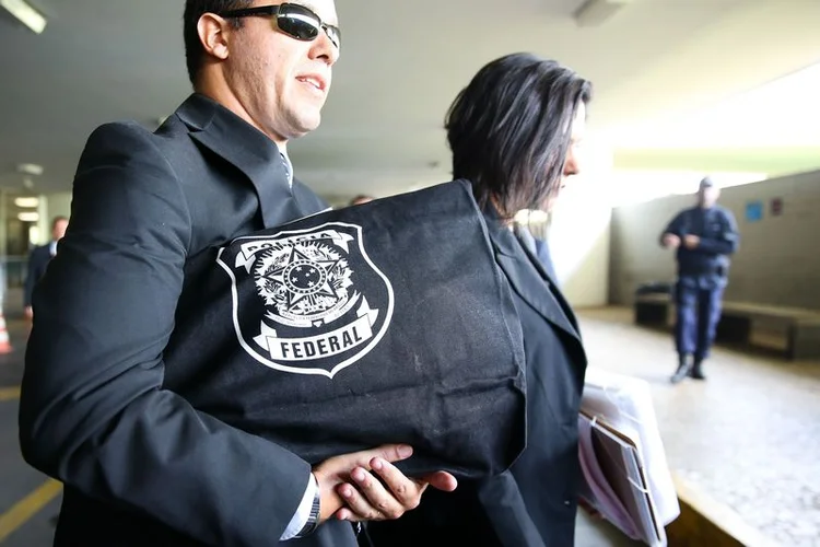 Agentes da Polícia Federal deixam o Congresso Nacional carregando malotes com apreensões feitas nos gabinetes dos senadores Aécio Neves e Zezé Perrela, e do deputado Rocha Loures, dia 18/05/2017 (Marcelo Camargo/Agência Brasil)