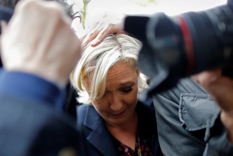 Equipe protege a candidata francesa Marine Le Pen quando opositores tentam atirar ovos nela no dia 04/05/2017 (Stephane Mahe/Reuters)