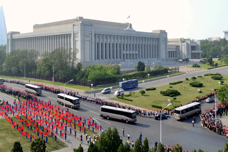 Desfile: adultos, estudantes e crianças festejaram a passagem do comboio de ônibus que transportou aos cientistas (KCNA/Reuters)