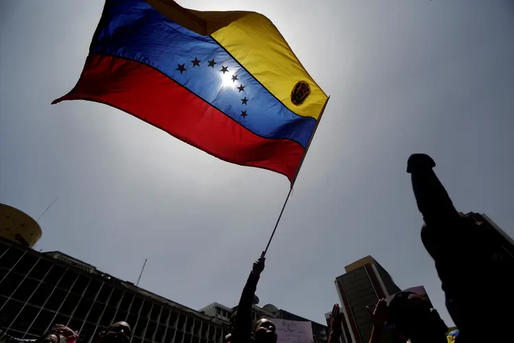Bandeira da Venezuela erguida em protesto: sanções devem incluir a estatal PDVSA (Marco Bello/Reuters)