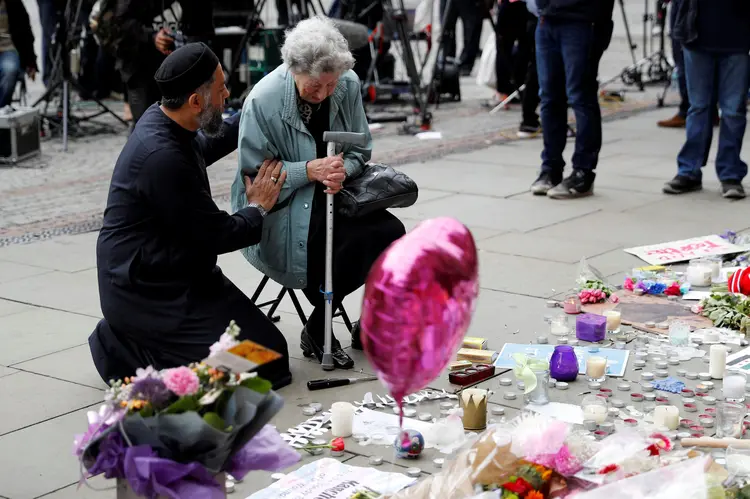 Pessoas deixam flores e homenagens a vítimas de ataque durante show em Manchester no dia 22/05/2017 (Darren Staples/Reuters)