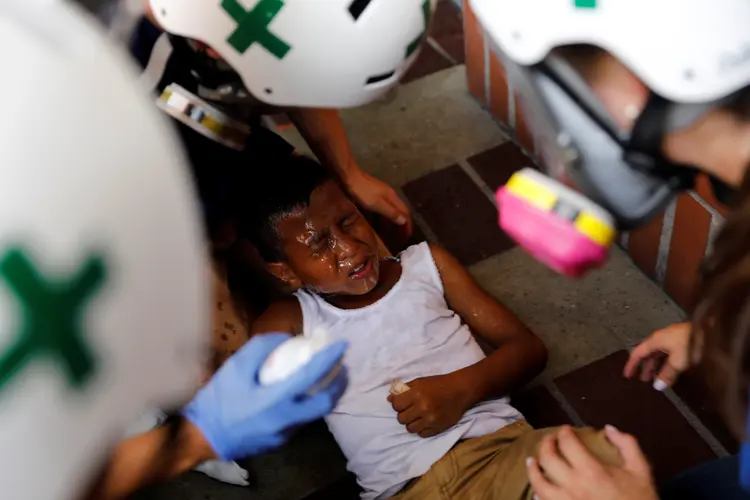 Criança recebe primeiros socorros de voluntários durante protesto contra o governo em Caracas, Venezuela, dia 24/05/2017 (Carlos Garcia Rawlins/Reuters)