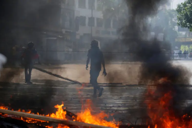 Manifestantes queimam barricadas em Caracas, dia 24/05/2017 (Carlos Barria/Reuters)