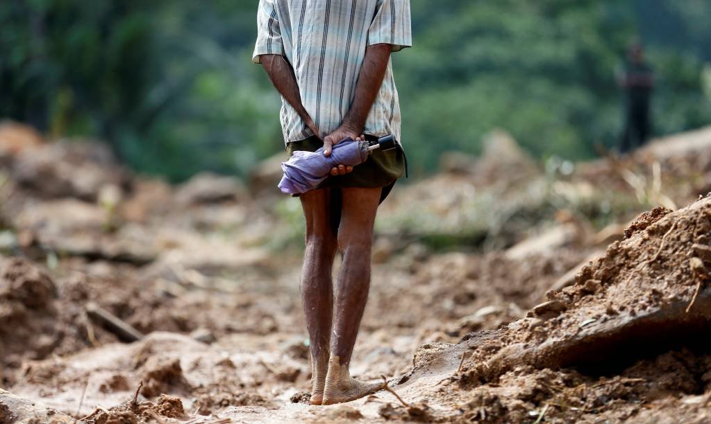 Homem observa deslizamentos de terra durante missão de resgate em Kalutara, no Sri Lanka (Dinuka Liyanawatte/Reuters)