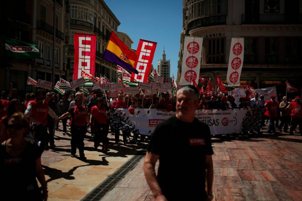Trabalhadores e sindicalistas seguram cartazes durante protesto do Dia do Trabalhador, na Espanha: países celebram o dia 1º de maio como Dia do Trabalhador, Dia do Trabalho ou Dia Internacional do Trabalhador (Jon Nazca/Reuters)