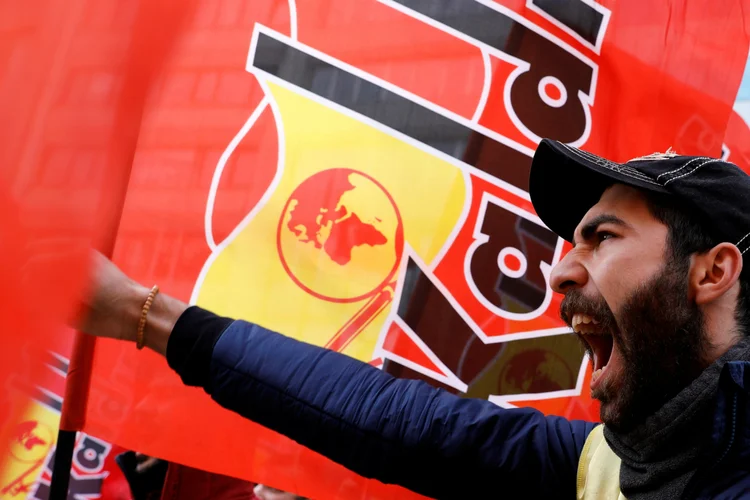 Homem grita em protesto com cartazes na praça Taskim, em Istambul (Turquia): país comemora o Dia do Trabalho em um clima de tensão (Umit Bektas/Reuters)