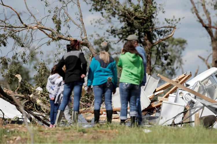 Jovens olham para casa destruída por tornado no Texas: tornados no estado causaram a morte de quatro pessoas (Brandon Wade/Reuters)