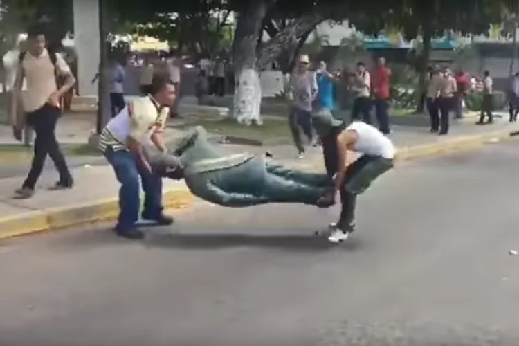 Protestos na Venzuela: manifestantes jogaram a estátua de Hugo Chávez na rua diversas vezes (YouTube/Reprodução)