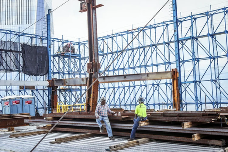 TRABALHADORES NO WORLD TRADE CENTER: os déficits têm de ser encarados como algo a ser financiado pela inflação futura, não por futuros impostos ou cortes de gastos / George Etheredge/The New York Times