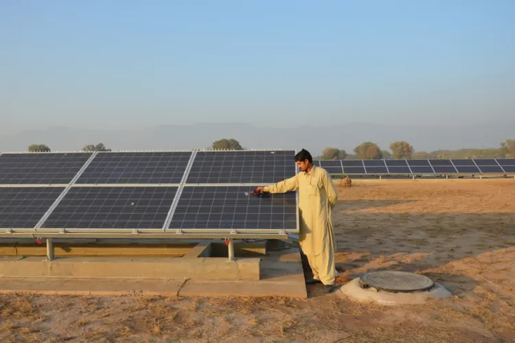 PAQUISTÃO: Funcionário limpa nova placa de energia solar no parque Fatima Jinnah, na cidade de Islamabad / Saleem Shaikh and Sughra Tunio/TRF/Reuters