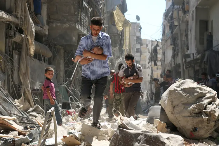 ALEPO: imagem de sírios carregando bebês em meio às ruínas após ataque aéreo foi premiada em competição mundial de fotografia / Ameer Alhalbi/World Press Photo Foundation/Reuters