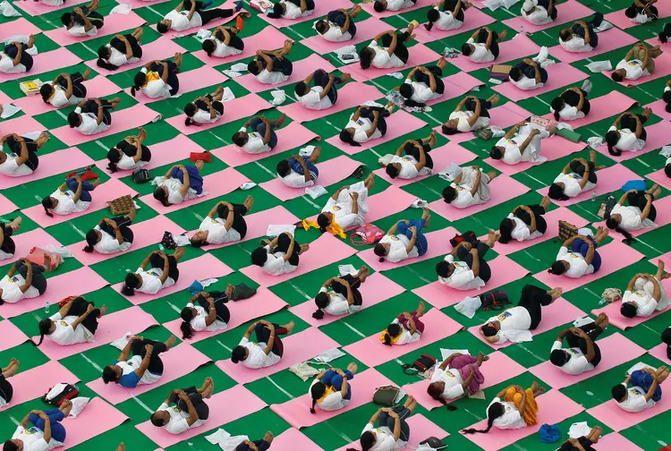 Indianos praticam ioga:"Quando todos juntos, no mesmo momento, realizamos os mesmos movimentos, é algo único" (Ajay Verma/Reuters)