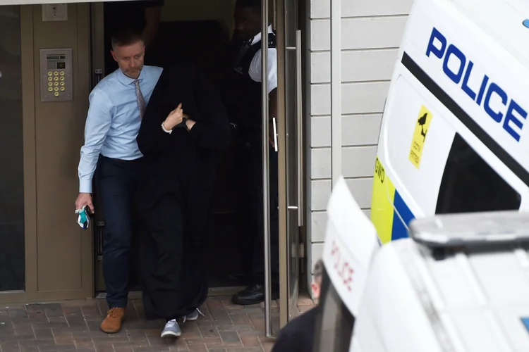 Policial leva mulher para uma van no bairro de Barking, em Londres: conexão com o crime (Hannah McKay/Reuters)