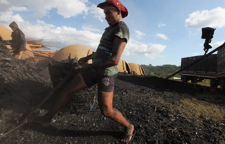 AMAZÔNIA: trabalhador faz carregamento de carvão em área desmatada ilegalmente, em Rondônia; esse tipo de empreendimento está cada vez na mira do governo, que tenta se tornar referência global em sustentabilidade / Mario Tama / Getty Images
