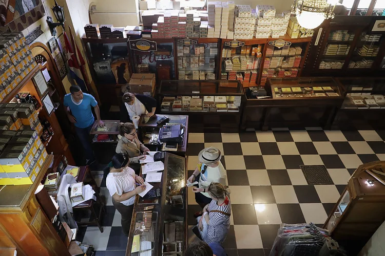 HAVANA: Turistas em tabacaria tradicional da capital cubana / Chip Somodevilla/Getty Images)