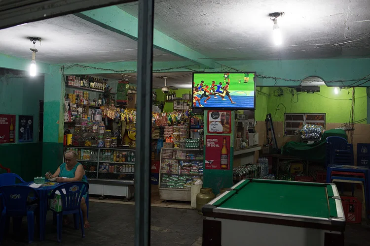 RIO DE JANEIRO: na favela do Vidigal, mulher acompanha vitória do velocista Usain Bolt na disputa dos 100 metros rasos, nas Olimpíadas do Rio  / Chris McGrath/Getty Images