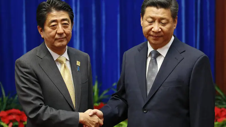 XI JINPING E SHINZO ABE: presidentes de China e Japão se cumprimentam. Estudo mostra que japoneses e chineses têm visões majoritariamente negativas sobre o outro (Kim Kyung-Hoon/Reuters)