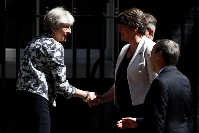 May e a líder do DUP, Arlene Foster, acompanharam a assinatura do acordo em Downing Street nesta segunda-feira (Stefan Wermuth/Reuters)