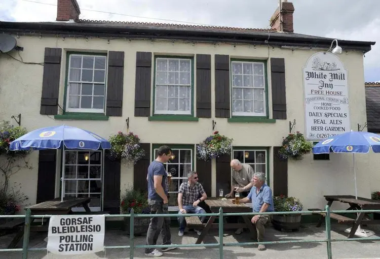 BREXIT: no País de Gales, eleitores bebem cerveja do lado de fora de um pub que foi usado como seção eleitoral  / Rebecca Naden/Reuters