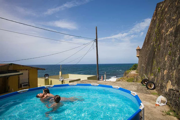 PORTO RICO: família brinca em piscina de plástico na favela de La Perla, a maior da ilha americana / Angel Franco/The New York Times