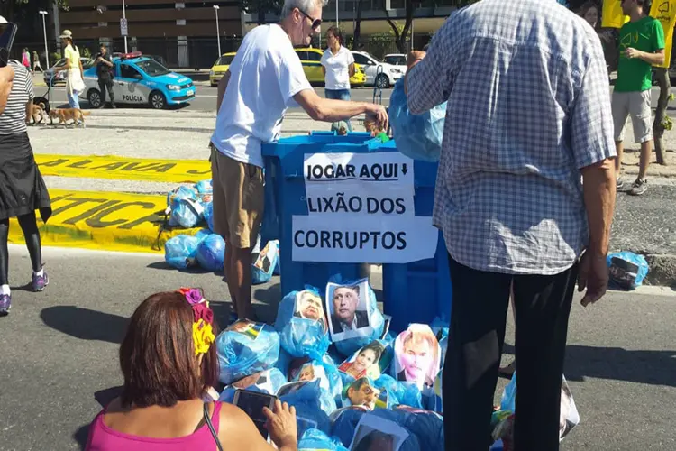 Grupo fez protesto com uma lixeira, na qual foram colocados diversos sacos de lixo com a imagem de políticos (Facebook/Vemprarua RJ/Divulgação)