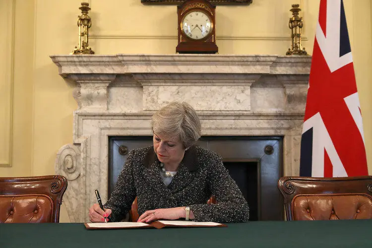 O ARTIGO 50: em seu gabinete, a primeira ministra Theresa May assina a carta para o presidente do Conselho Europeu, Donald Tusk / REUTERS/Christopher Furlong
