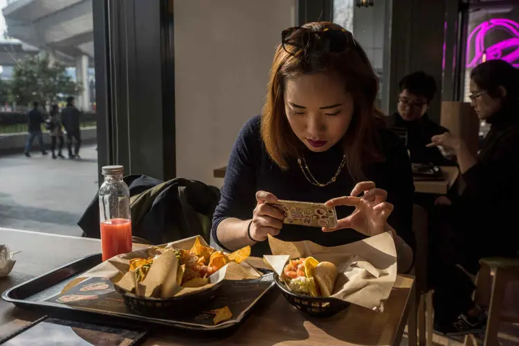 LIU XIAOYI, EDITORA DE UM GUIA GASTRONÔMICO DE XANGAI: para conquistar os chineses, a Taco Bell vende bebidas alcóolicas e cortou o feijão  / Gilles Sabre/The New York Times