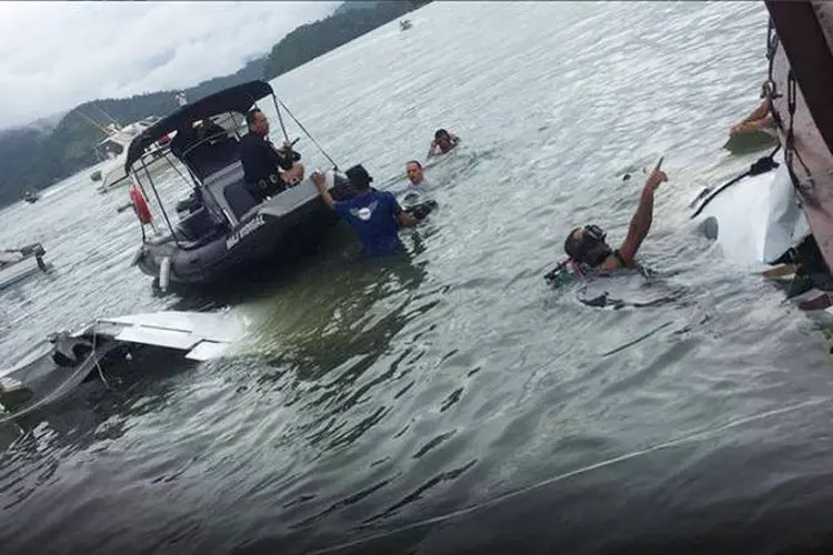 PARATY: A empresa AGS reboca os destroços com uma balsa para levar a lataria até a praia em Angra dos Reis, de onde seguirá para perícia / Marinha/ Divulgação