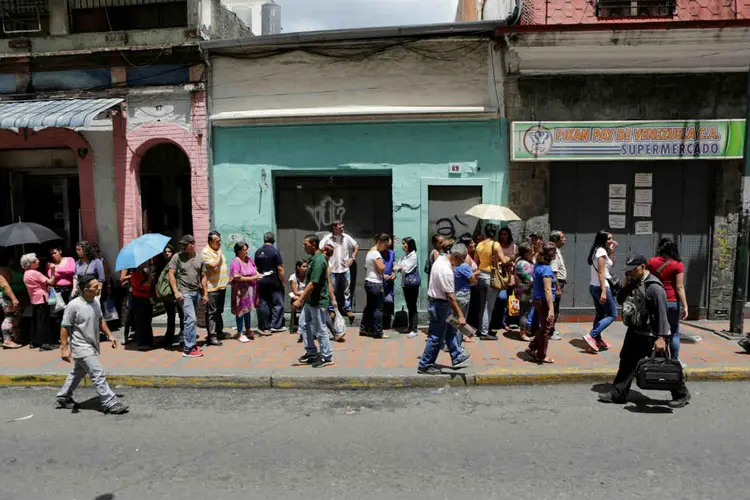 VENEZUELA: fila para comprar itens básicos do lado de fora de um supemercado / Marco Bello/ Reuters