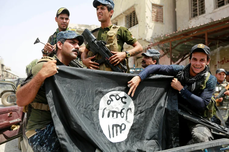 Policiais do Iraque seguram bandeira do Estado Islâmico após expulsar os militantes de Mosul, dia 04/07/2017 (Ahmed Saad/Reuters)