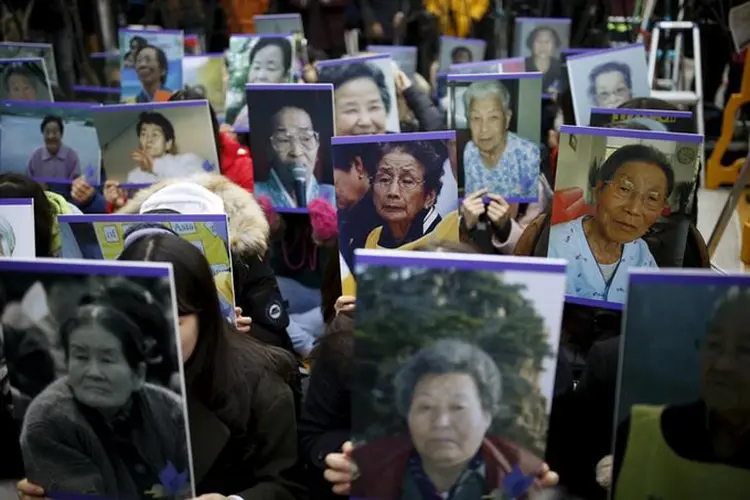 Estudantes seguram retratos de "mulheres de conforto" sul-coreanas falecidas em frente à embaixada japonesa em Seul (Kim Hong-Ji/Reuters)