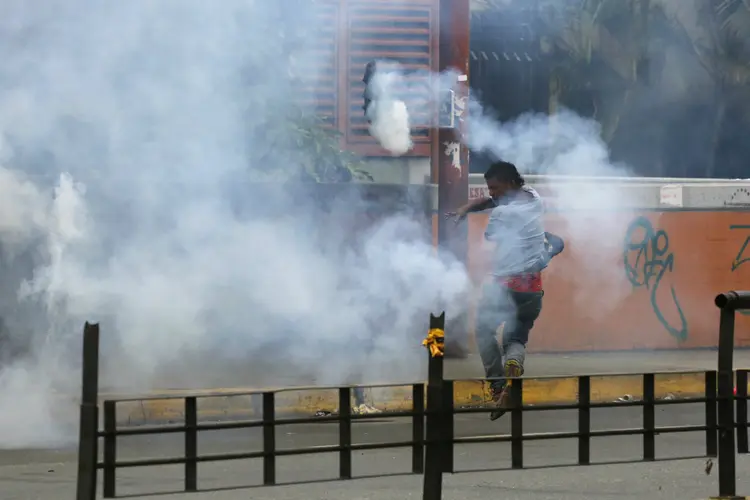 Manifestante arremessa bomba de gás durante votação da Constituinte na Venezuela: confrontos com forças de ordem acontece em vários locais (Carlos Garcia Rawlins/Reuters)