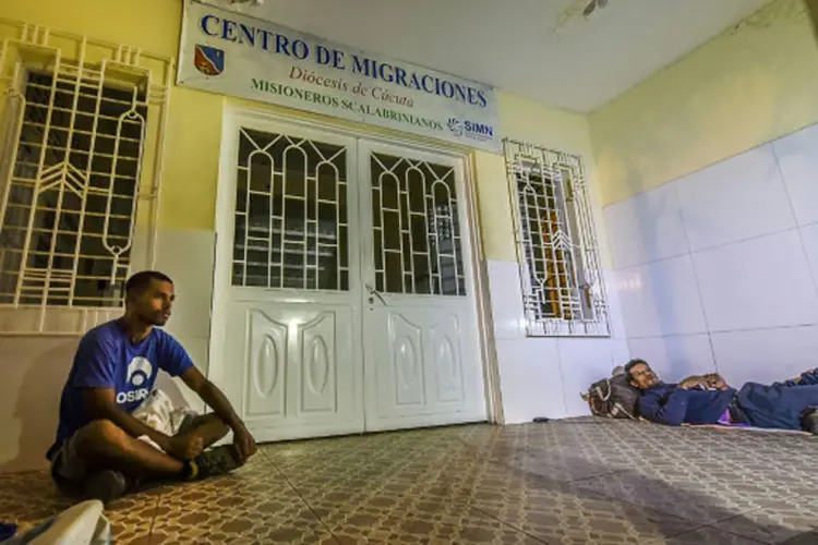 Venezuela: os venezuelanos José Flores (d) e Rafael Mendoza aguardam em frente ao Centro de Migrações de Cúcuta, Colômbia (Luis Acosta/AFP)