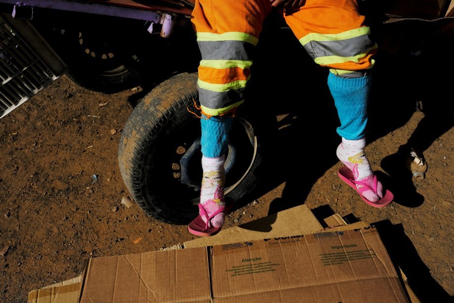 Fabiana, catadora e ex-moradora de rua, sentada em sua carroça
