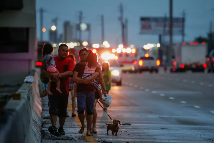 Família escapa de alagamento em Houston após a passagem do furacão Harvey (Adrees Latif/Reuters)