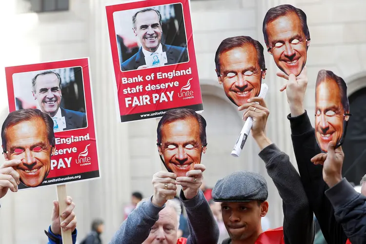 Funcionários: seguram cartazes dizendo "Equipe do Banco da Inglaterra quer salário justo" enquanto caminham em direção ao edifício do BoE (Peter Nicholls/Reuters)
