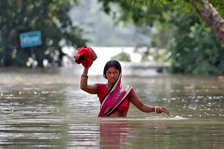 Mulher atravessa área alagada no estado de Bihar na Índia em 22 de agosto de  2017.  (Cathal McNaughton/Reuters)