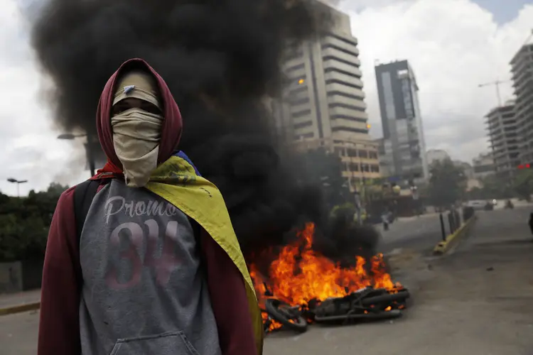 Opositor caminha durante protesto contra a convocação de uma assembleia constituinte na Venezuela (Carlos Garcia Rawlins/Reuters)