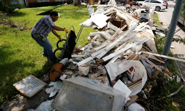 Homem leva detritos até uma pilha do lixo das enchentes que tomaram Houston, no Texas, EUA (REUTERS/Rick Wilking/Reuters)